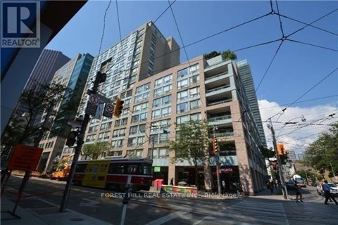 A street view of a city with a building in the background and a sign that says Forest Hill Real Estate.