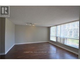 A room with wooden floors and a window with blinds.