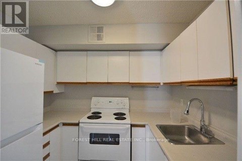 A white stove and sink in a small kitchen.