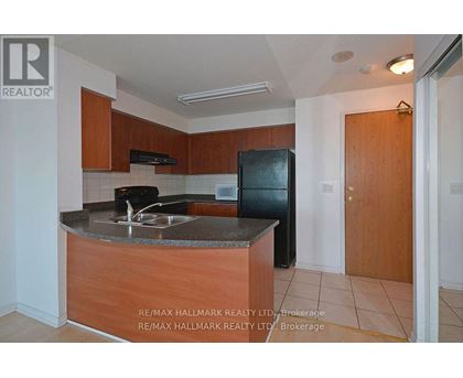 A kitchen with a sink and a refrigerator.