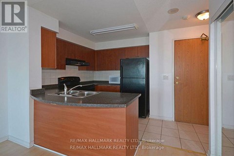 A kitchen with a sink and a refrigerator.