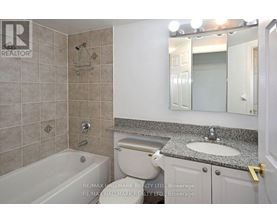 A bathroom with a tub, toilet, and sink.