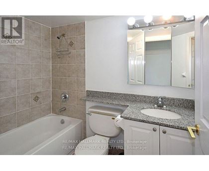 A bathroom with a tub, toilet, and sink.