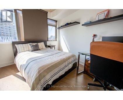 A bedroom with a bed, desk, and chair.