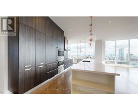 A modern kitchen with dark wood cabinets and a large window overlooking the city.