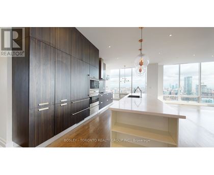 A modern kitchen with dark wood cabinets and a large window overlooking the city.