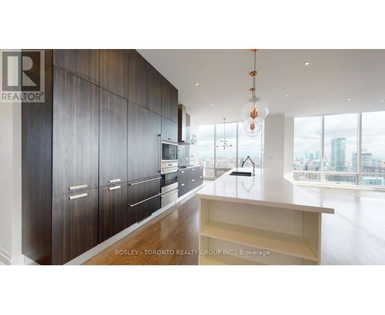 A modern kitchen with dark wood cabinets and a large window overlooking the city.