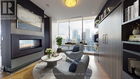 A living room with a grey couch and a fireplace.