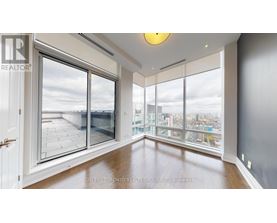 A spacious room with a view of the city through large windows.