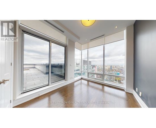 A spacious room with a view of the city through large windows.