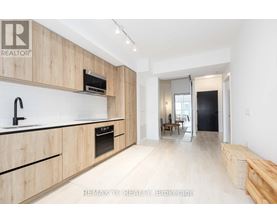 A modern kitchen with wooden cabinets and a black oven.