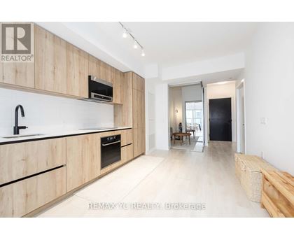 A modern kitchen with wooden cabinets and a black oven.