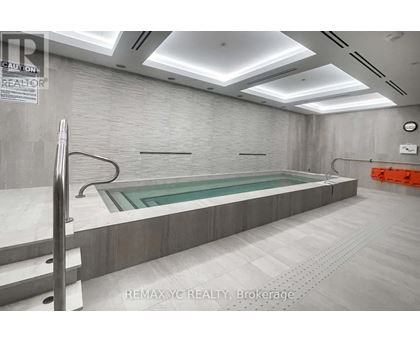 A large indoor swimming pool with a glass bottom.