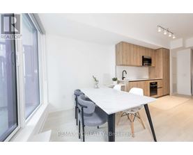 A dining area with a white table and grey chairs.