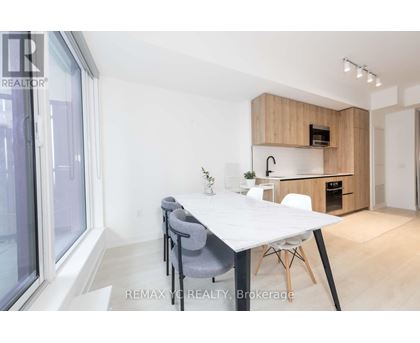 A dining area with a white table and grey chairs.