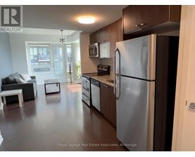 A kitchen with a refrigerator, microwave, and oven.