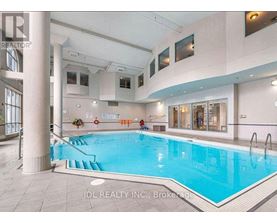 A large indoor swimming pool with a slide and a person sitting on the edge.