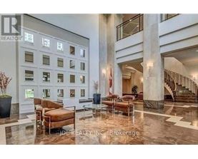 A spacious lobby with a marble floor and a staircase.