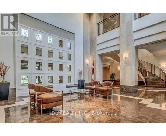 A spacious lobby with a marble floor and a staircase.