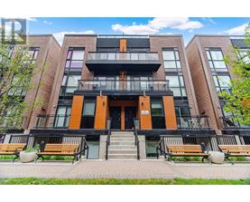 A modern apartment building with a black and orange facade.