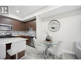 A modern kitchen with a glass table and white chairs.