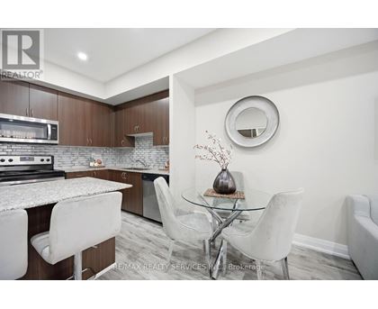 A modern kitchen with a glass table and white chairs.