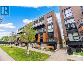 A modern apartment complex with a well-maintained lawn and benches.