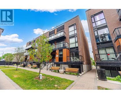 A modern apartment complex with a well-maintained lawn and benches.