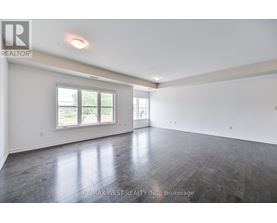 A spacious room with wooden floors and a large window.