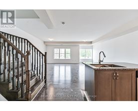 A spacious kitchen with a wooden cabinet and a dark hardwood floor.