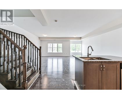 A spacious kitchen with a wooden cabinet and a dark hardwood floor.