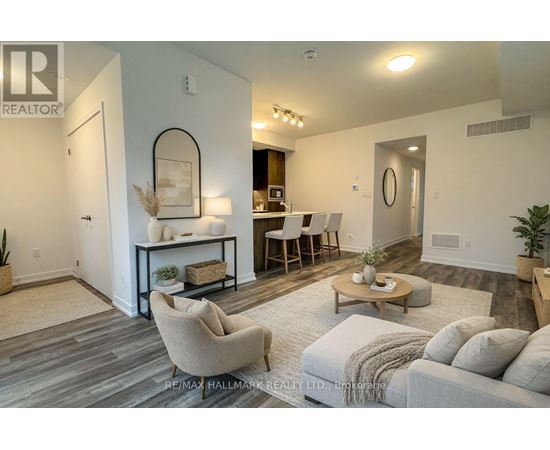 A living room with a grey couch, a coffee table, and a dining table with chairs.