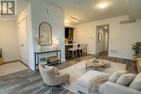 A living room with a grey couch, a coffee table, and a dining table with chairs.