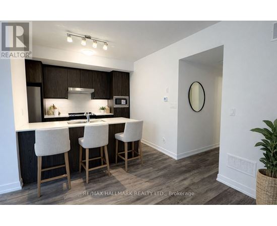 A kitchen with white chairs and a white counter top.