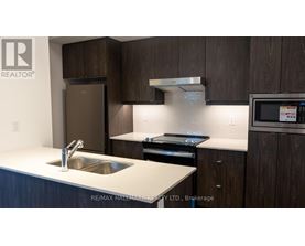 A modern kitchen with dark wood cabinets and stainless steel appliances.