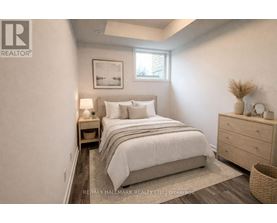 A bedroom with a bed, nightstand, and a basket on the floor.