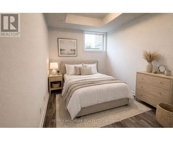 A bedroom with a bed, nightstand, and a basket on the floor.
