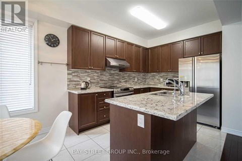 A kitchen with a granite countertop and wooden cabinets.