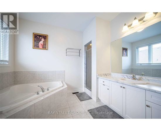 A bathroom with a large tub and double sinks.
