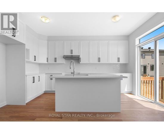 A kitchen with white cabinets and a wooden floor.