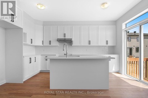 A kitchen with white cabinets and a wooden floor.