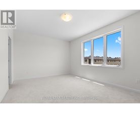 A white room with a window showing a view of a building.
