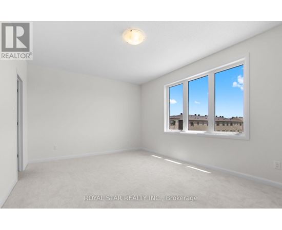 A white room with a window showing a view of a building.