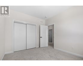A white bedroom with a door and a closet.