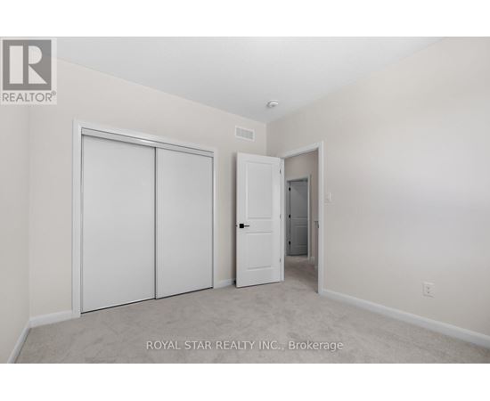 A white bedroom with a door and a closet.