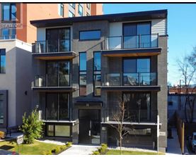 A modern two-story apartment building with balconies and glass doors.