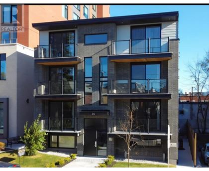 A modern two-story apartment building with balconies and glass doors.