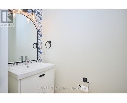 A white bathroom sink under a mirror with a floral design.