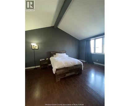 A bedroom with a bed, nightstand, and lamp.