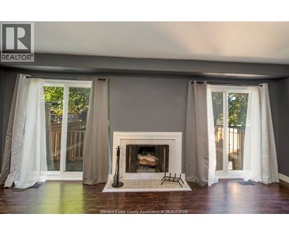 A living room with a fireplace and curtains.